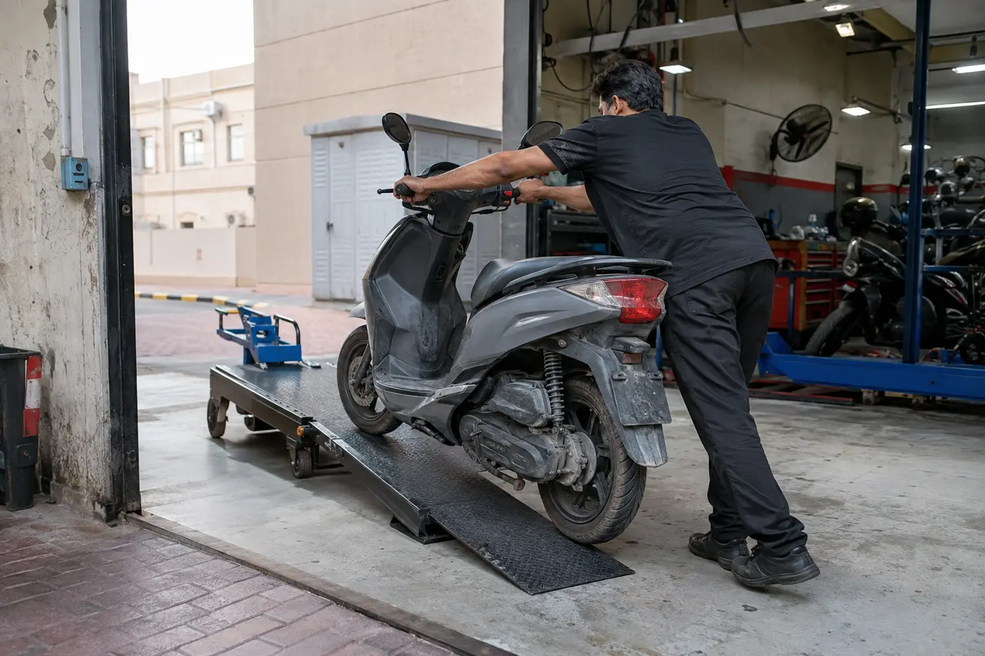Scooter being moved safely onto a motorcycle recovery platform